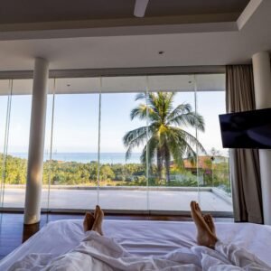 Luxury hotel room with ocean view and palm trees, perfect for a serene vacation.